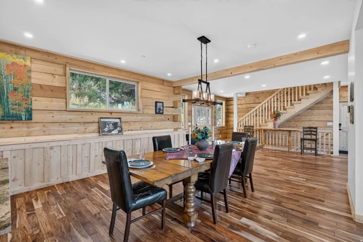 Dining area featuring wood-finish flooring, exposed beam accents, and recessed ceiling lighting
