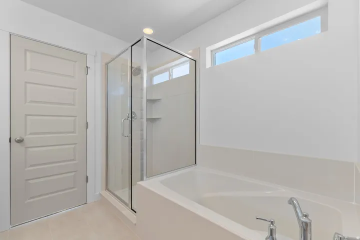 Walk-in shower with clear glass enclosure and built-in shelving