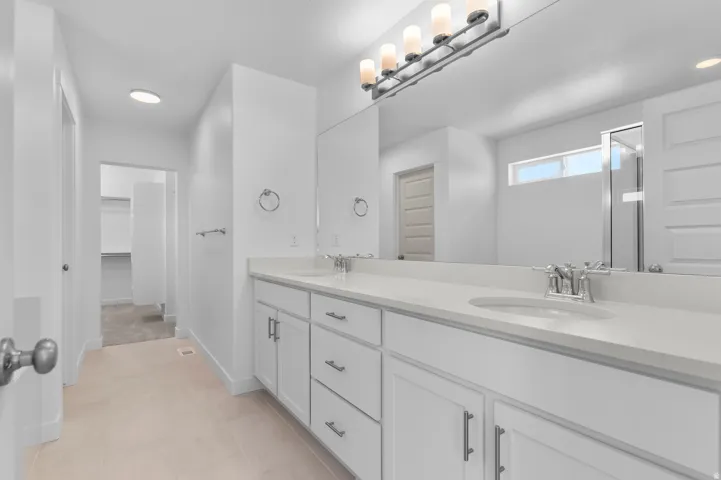 Dual vanity with white cabinetry, light-toned countertop, and undermount sinks