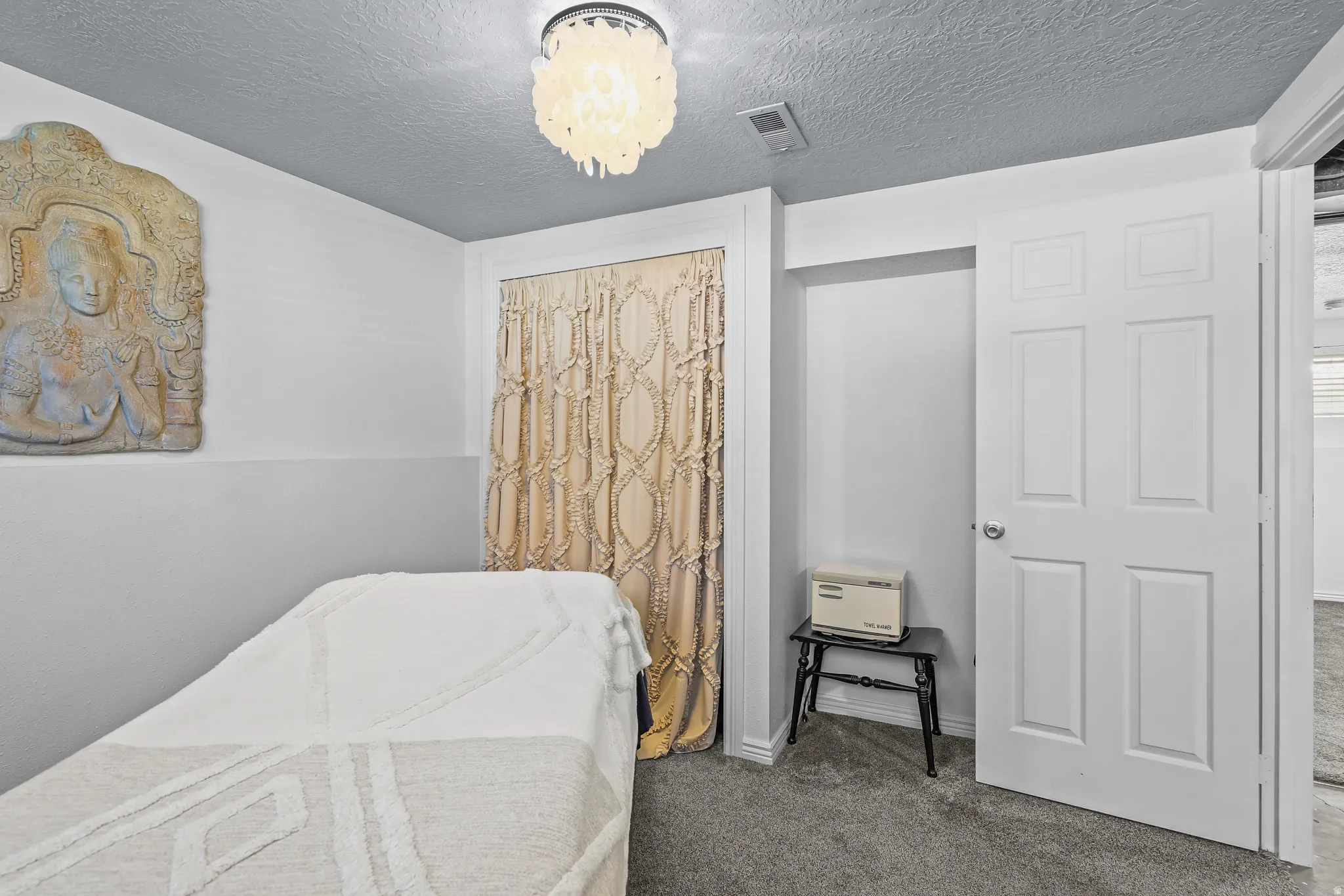 Room featuring gray carpeting, a white six-panel door, and a built-in recessed area