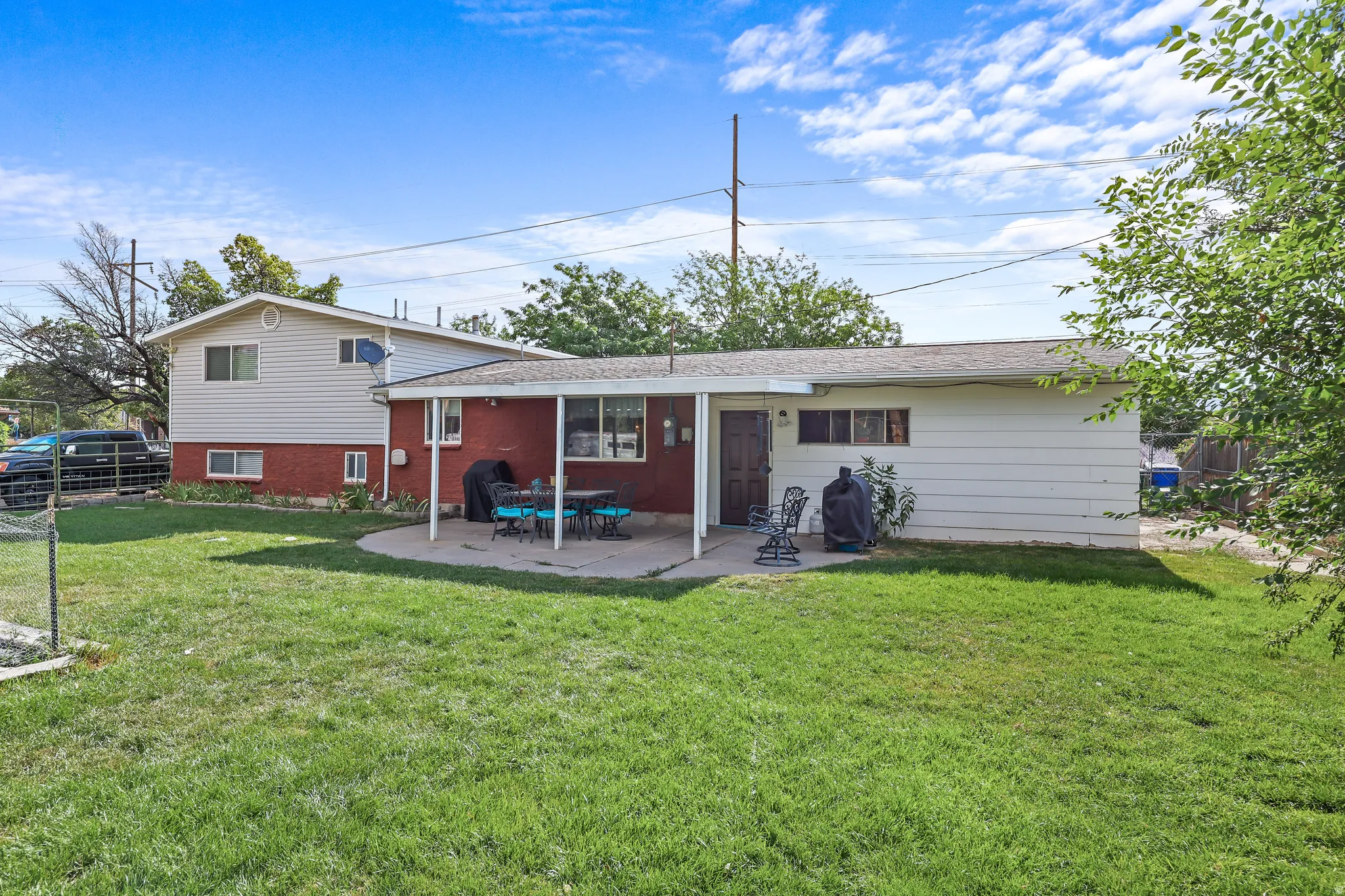 Expansive grass yard with a curved concrete patio and covered outdoor entertaining space