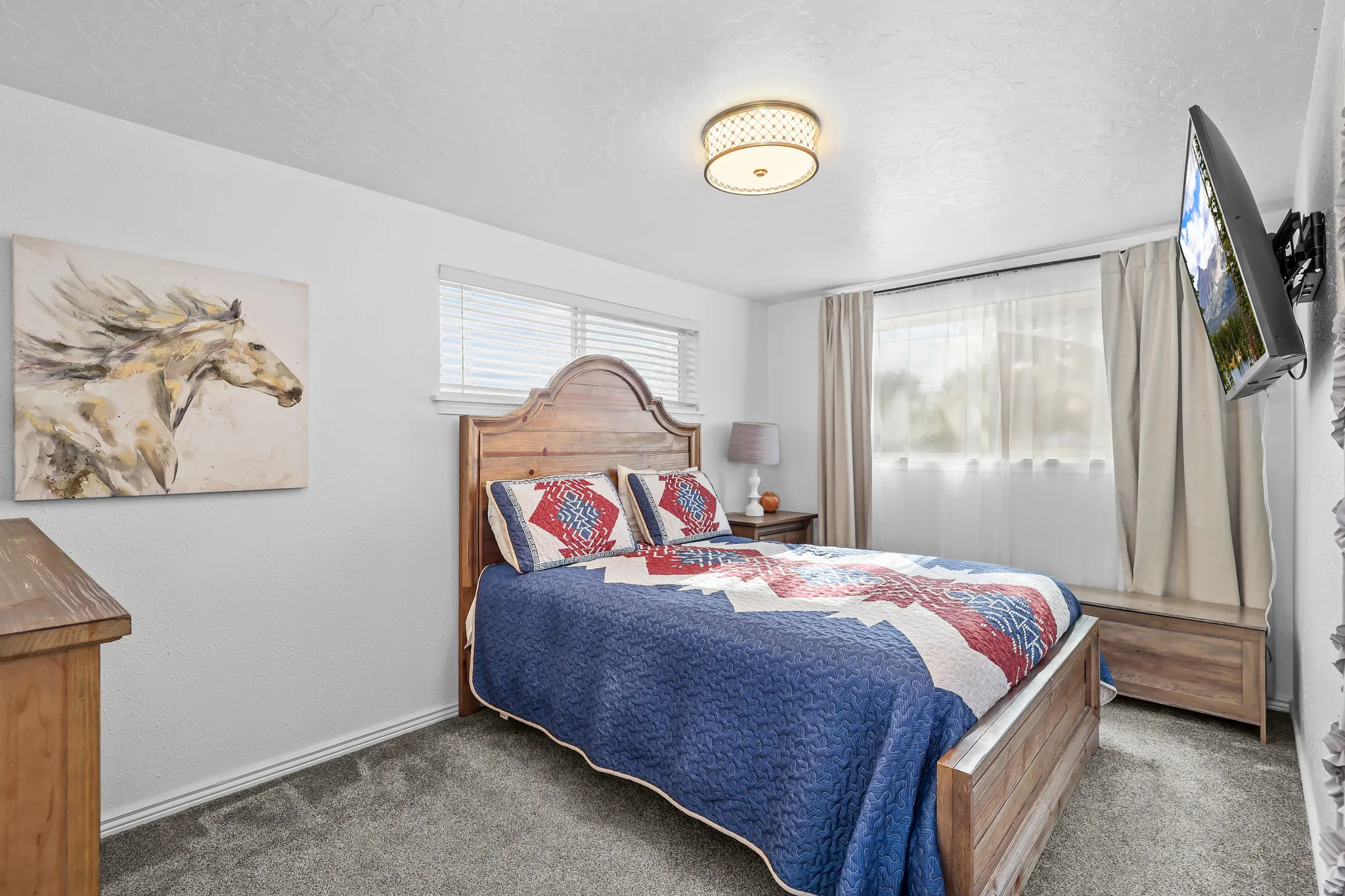 Bedroom featuring a wood-finish bed frame, light gray carpet, and white walls
