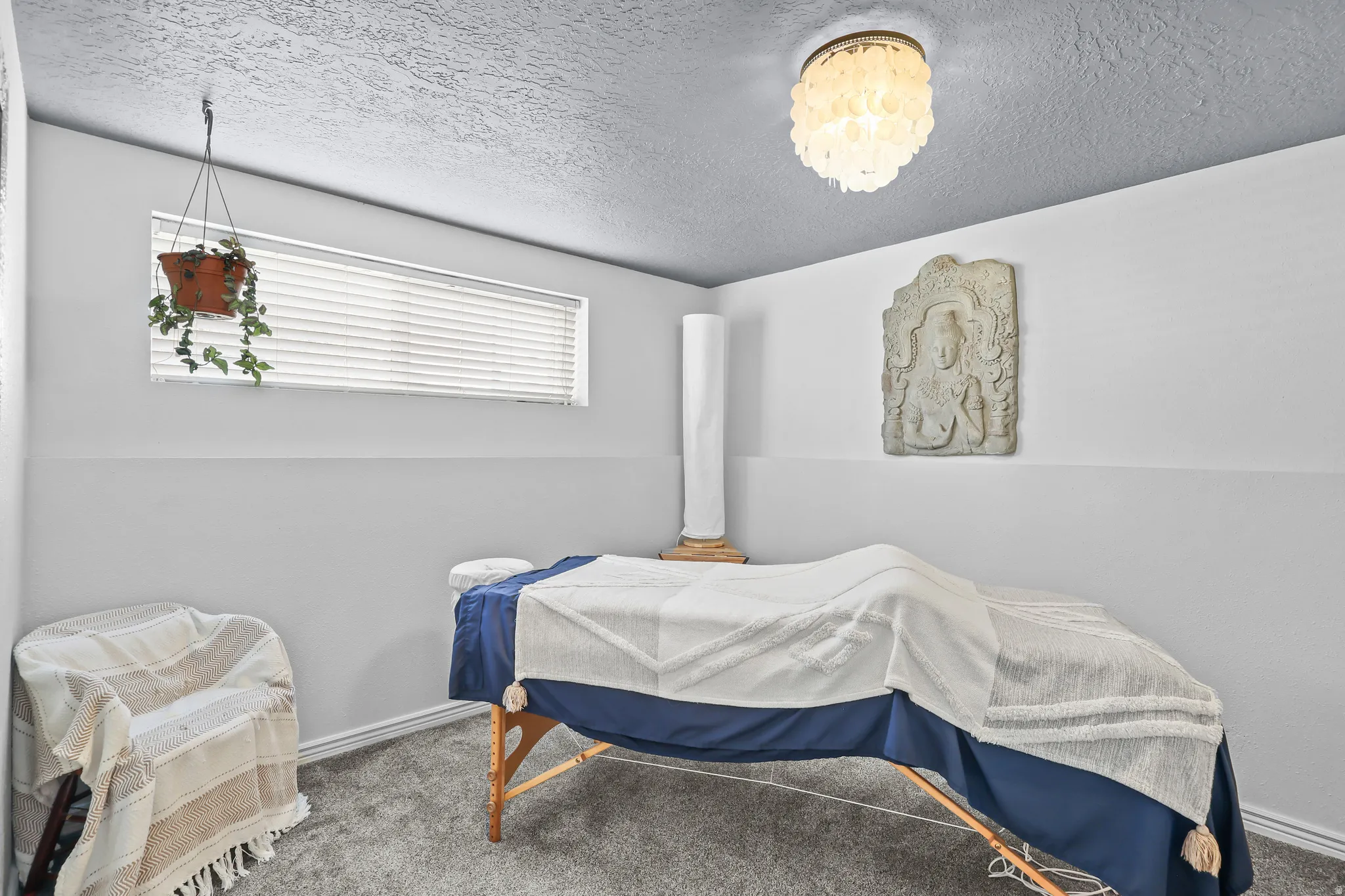 Room featuring textured gray carpeting, neutral wall paint, and a ceiling-mounted light fixture