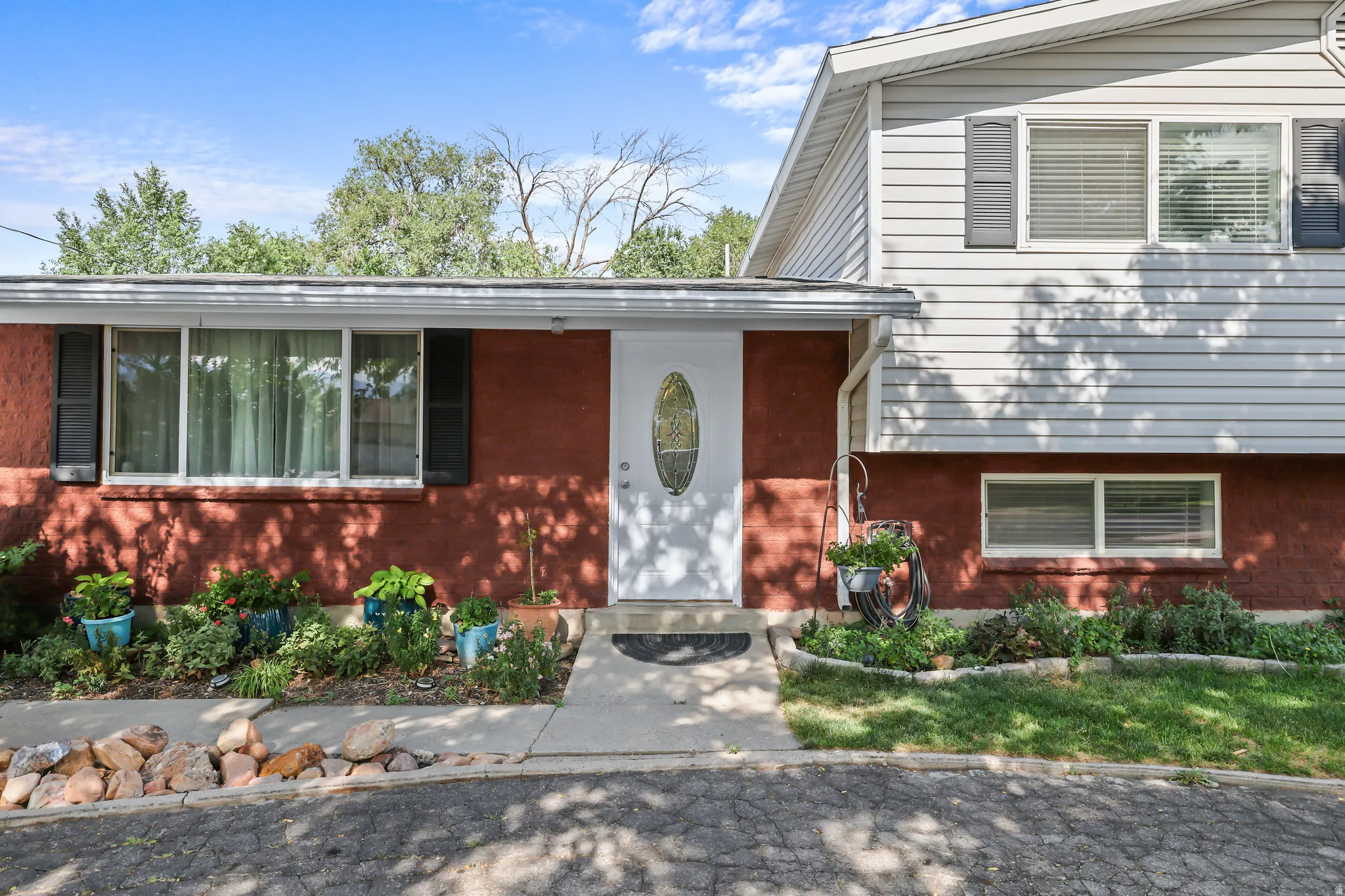 Split-level exterior featuring a combination of red brick and horizontal siding
