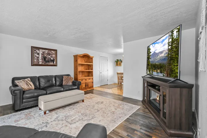 Spacious living area featuring wood-finish flooring and light-toned walls