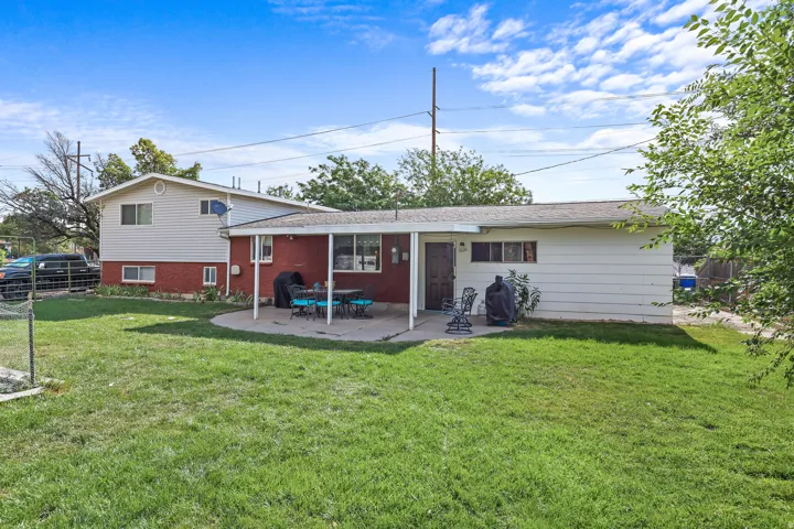 Expansive grass yard with a curved concrete patio and covered outdoor entertaining space