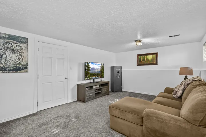 Recessed ceiling light fixture illuminating a spacious room with textured white walls