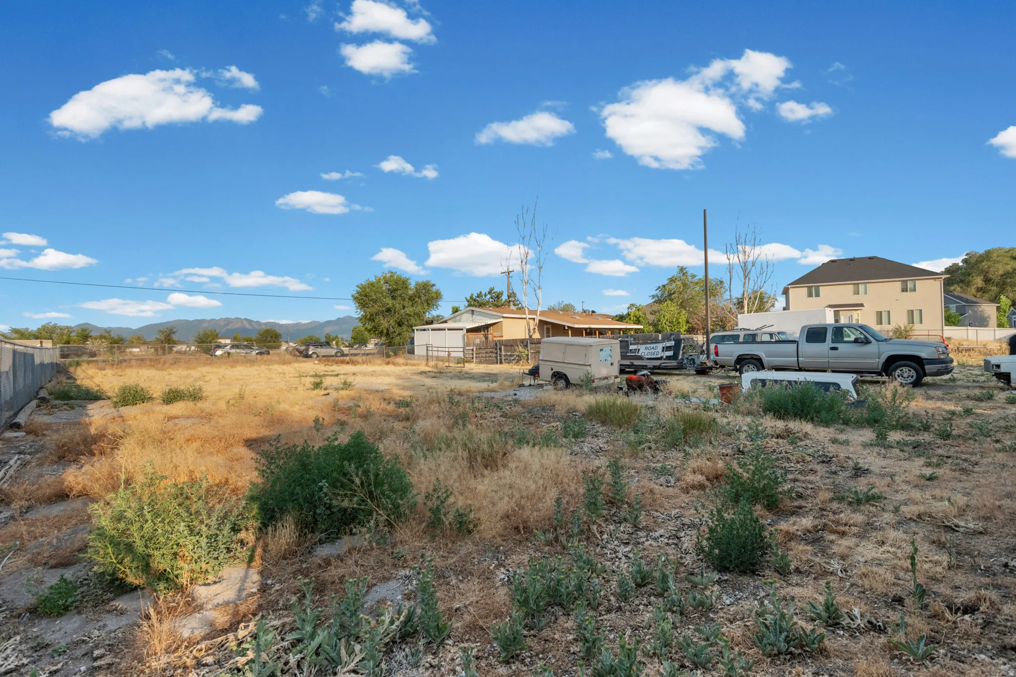 Expansive undeveloped lot featuring natural vegetation and a clear blue sky
