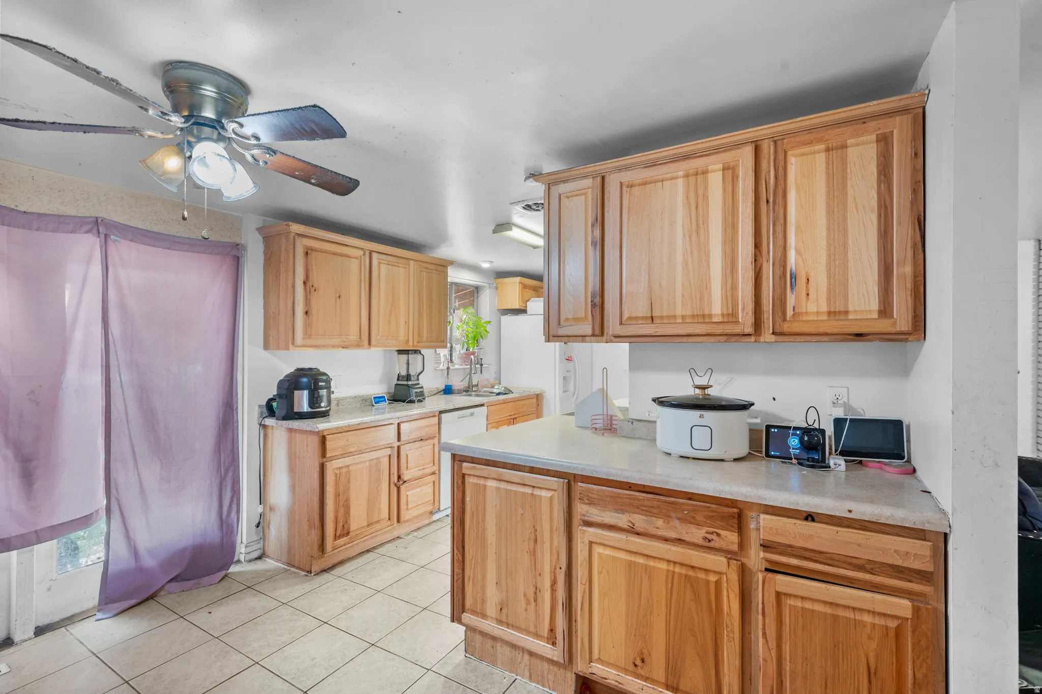Kitchen featuring wood cabinetry, light countertops, and tile flooring