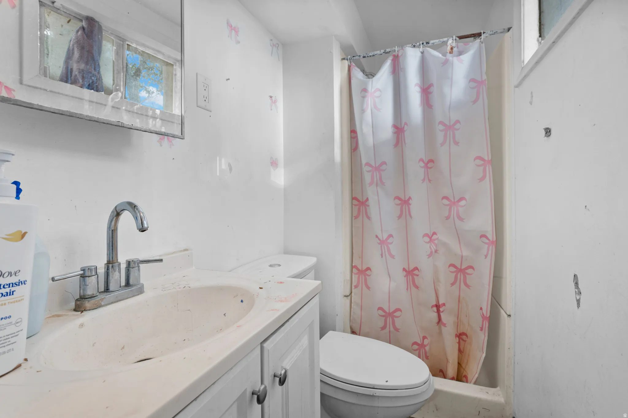 Bathroom vanity with a chrome faucet, medicine cabinet, toilet, and shower enclosure