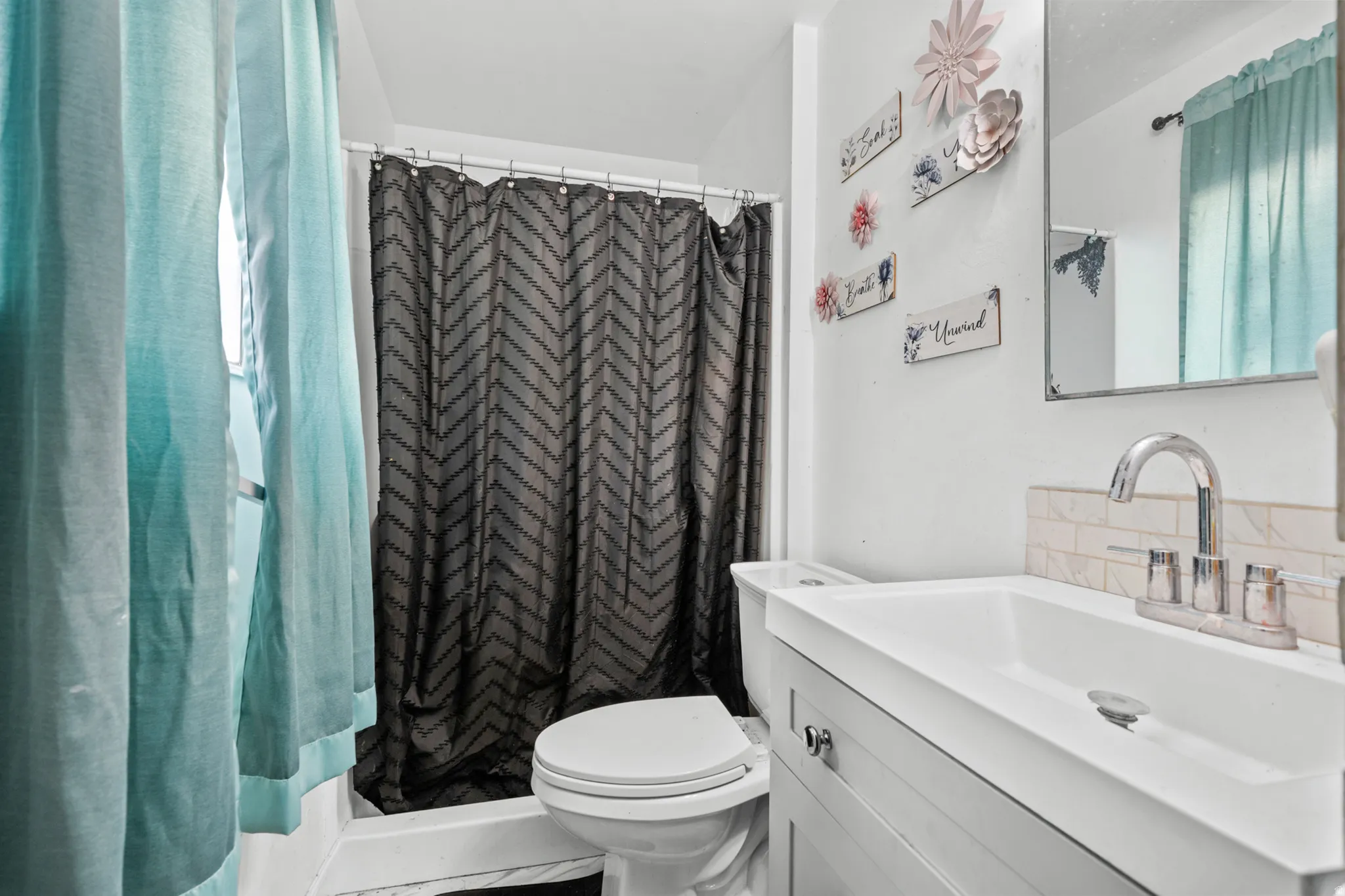 Full bathroom featuring a single vanity with chrome fixtures, a rectangular sink, and a white subway tile backsplash