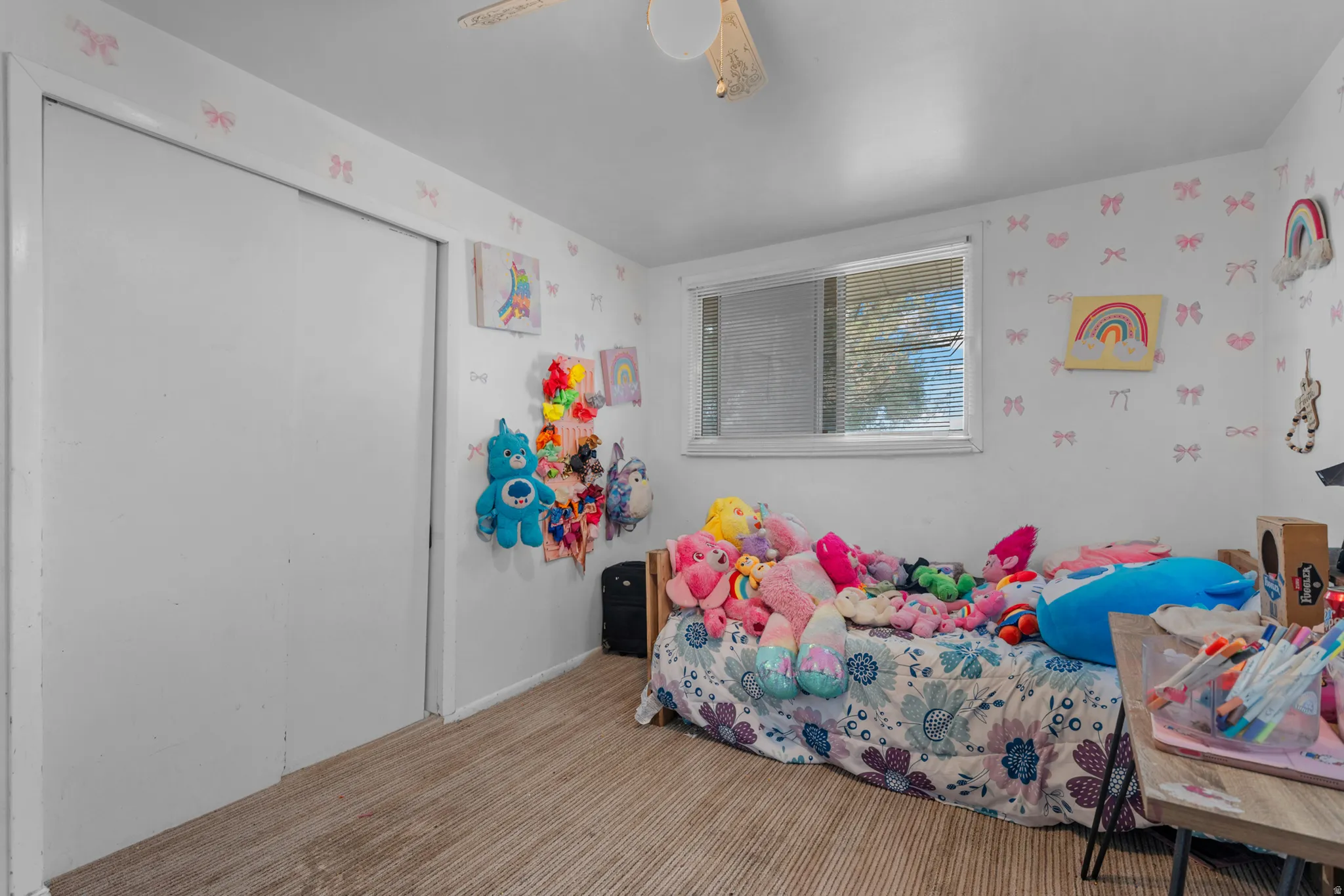 Room featuring a dual sliding closet, wood-finish flooring, and a window with blinds