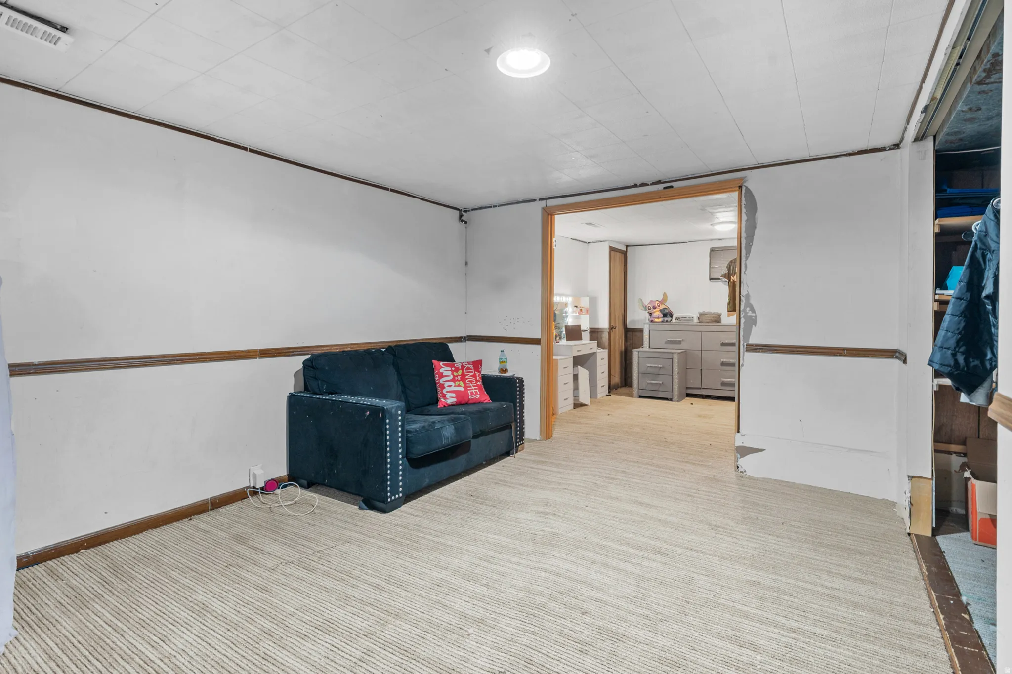 Finished room with light-toned wall-to-wall carpeting and wood trim accents