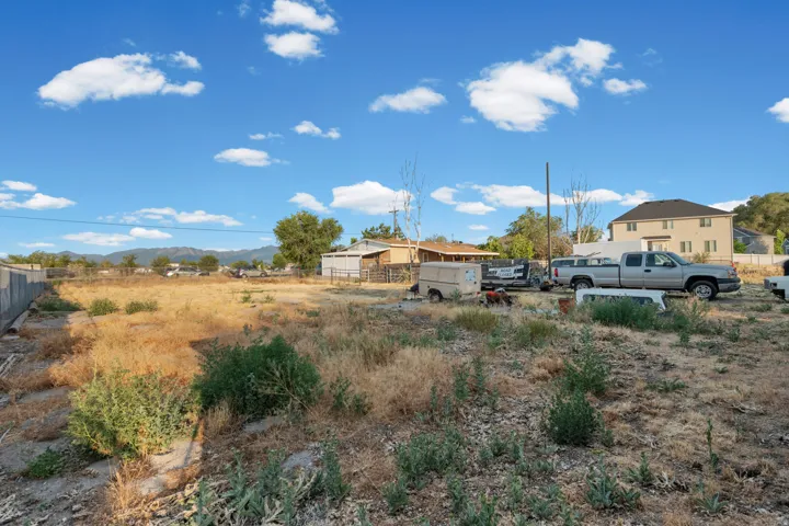 Expansive undeveloped lot featuring natural vegetation and a clear blue sky