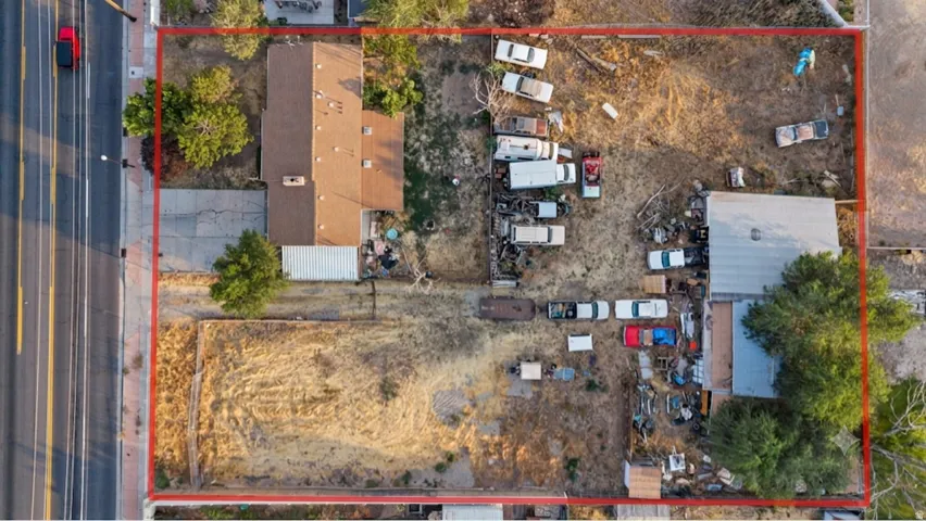 Aerial property overview featuring two distinct structures, a main residence with a brown shingle roof, and an additional auxiliary building with a metal roof