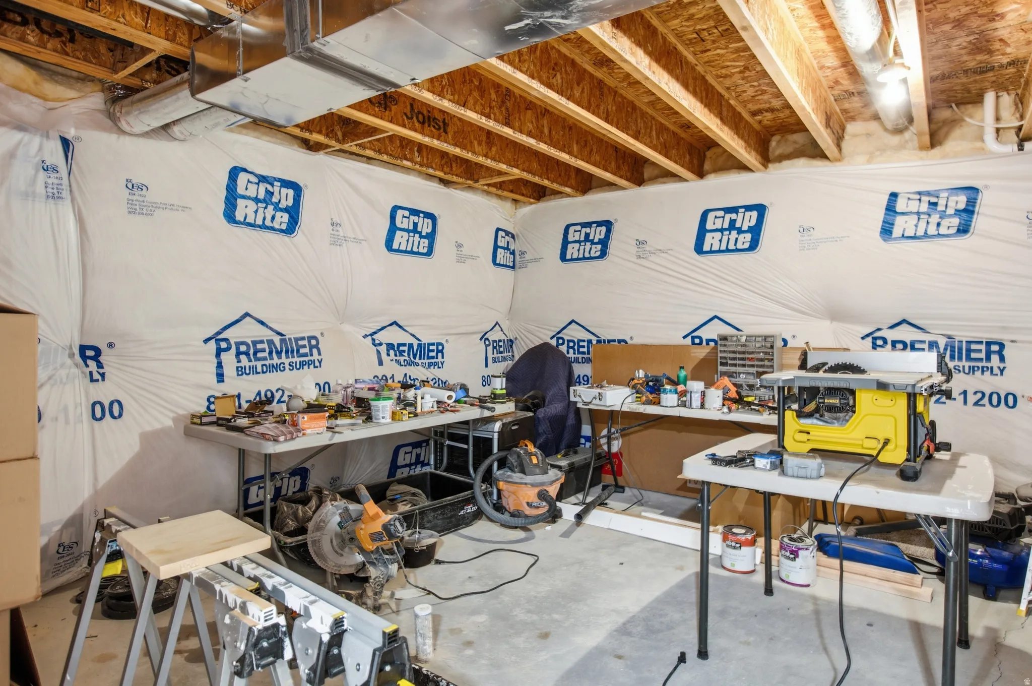 Unfinished basement space featuring exposed wood joists and concrete flooring