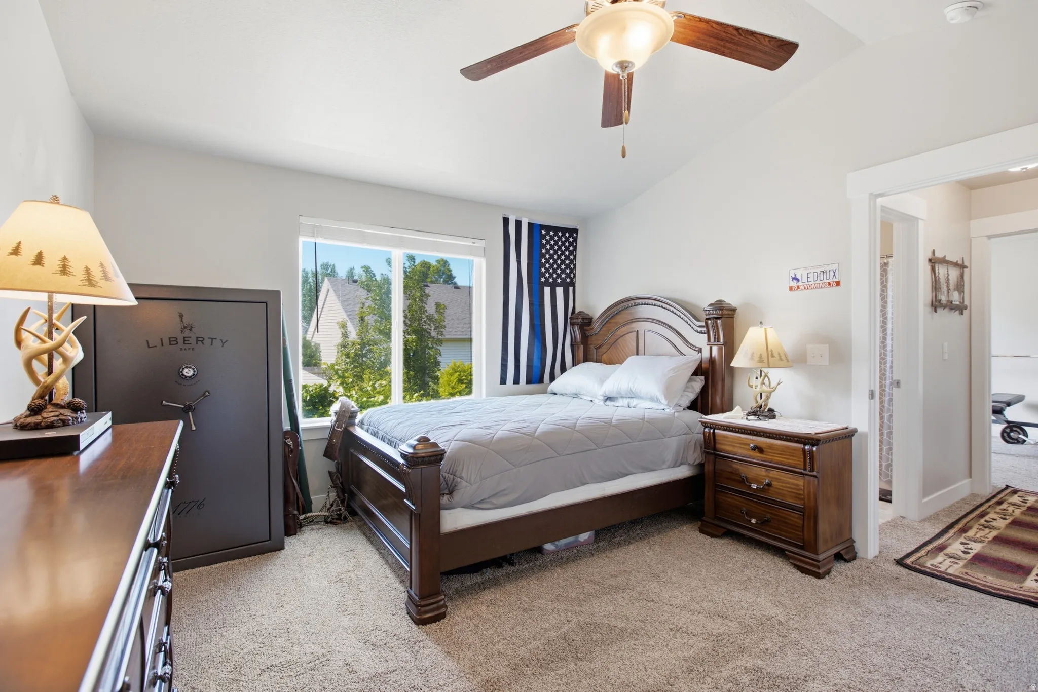 Carpeted room featuring a vaulted ceiling and a ceiling fan with integrated lighting