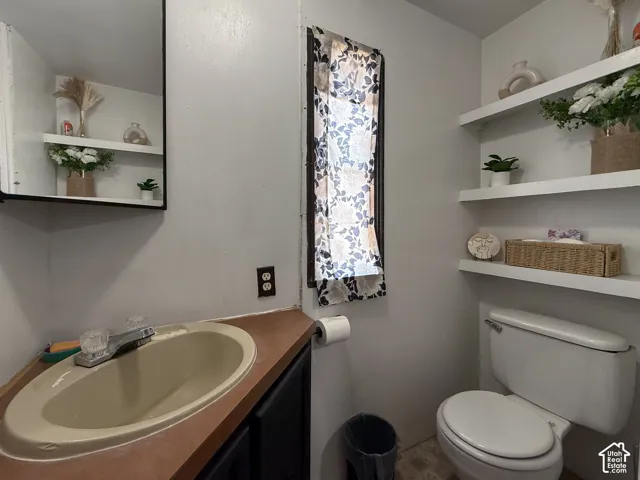Bathroom featuring a built-in vanity with an oval sink, dark wood-finish cabinetry, and a framed wall mirror