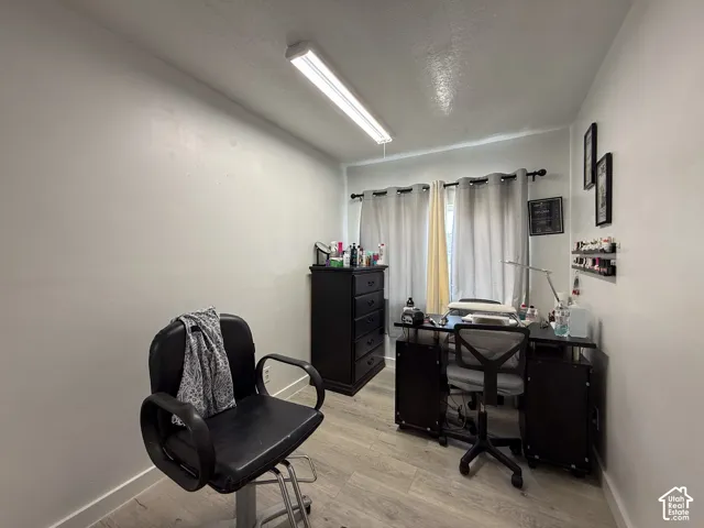 Neutral wall paint, ceiling-mounted fluorescent lighting, and wood-finish flooring