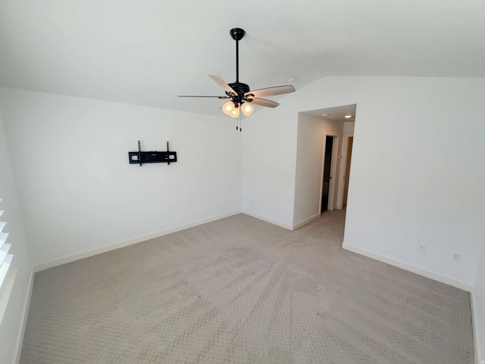 Spacious room with light-toned wall-to-wall carpeting and crisp white walls