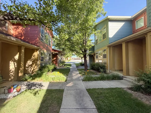Manicured concrete pathway bordered by green lawns and mature trees