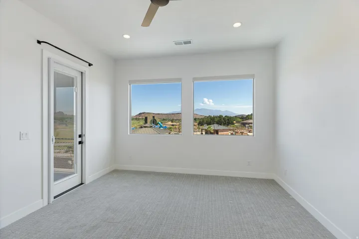 Bright interior space featuring recessed lighting, a ceiling fan, and light-toned patterned carpeting