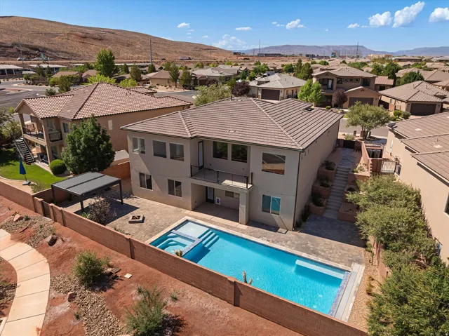 Backyard oasis featuring an in-ground swimming pool, integrated spa, and spacious paver patio