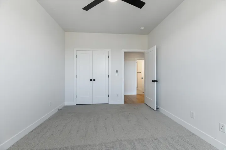 Light gray carpeted room featuring white walls and baseboards