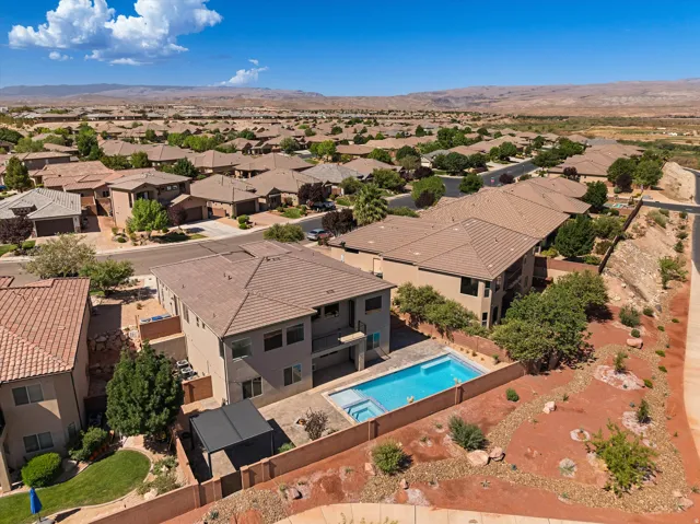 Suburban residence featuring a private pool with an integrated spa, an outdoor covered patio, and desert landscaping