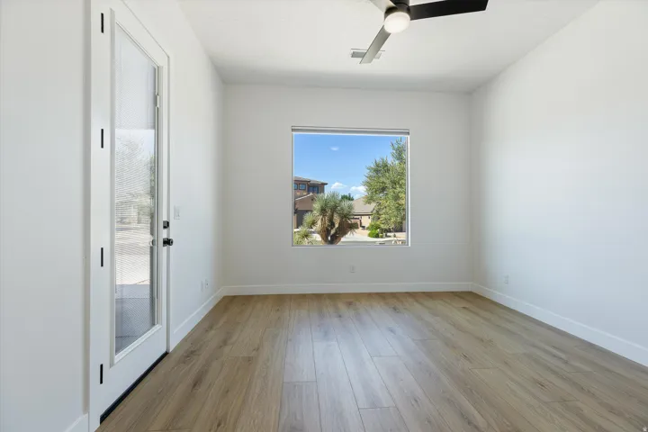 Neutral-toned wood-finish flooring complements white walls, creating a bright space
