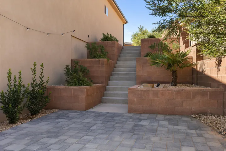 Paver patio area with tiered block retaining walls and integrated planters