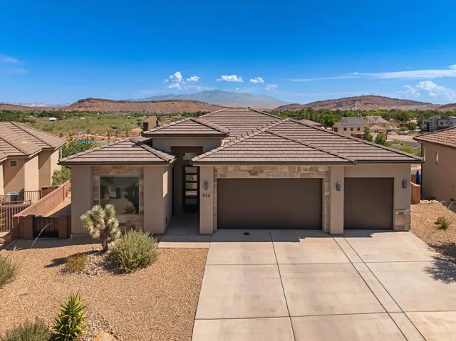 Modern stucco exterior with stone accents and a multi-car garage