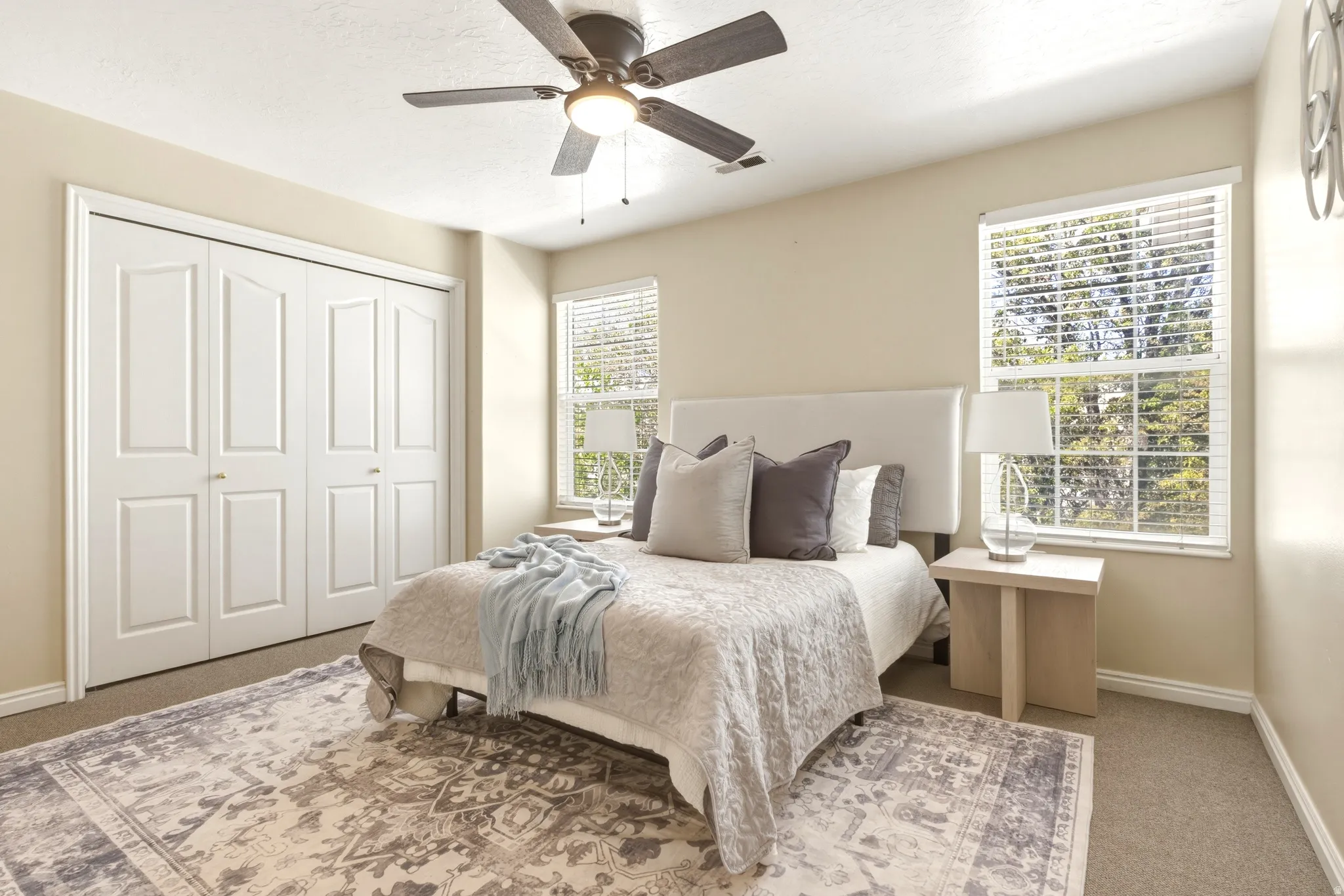 Bedroom featuring a ceiling fan with light fixture, carpeted flooring, and a window with blinds