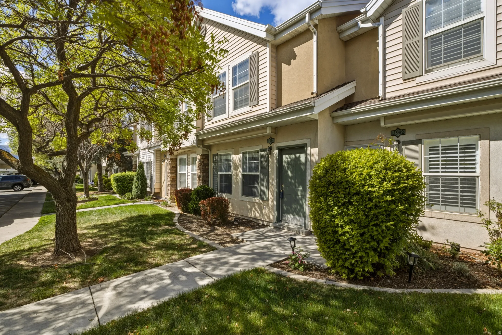 Townhome exterior featuring light-colored siding and stucco accents