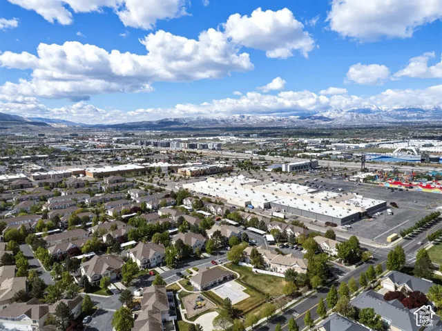 Aerial perspective showcasing a residential community with varied architectural styles, mature landscaping, and an adjacent commercial district