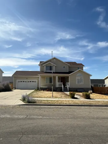 Two-story residence featuring a two-car garage, covered porch entry, and arched window details