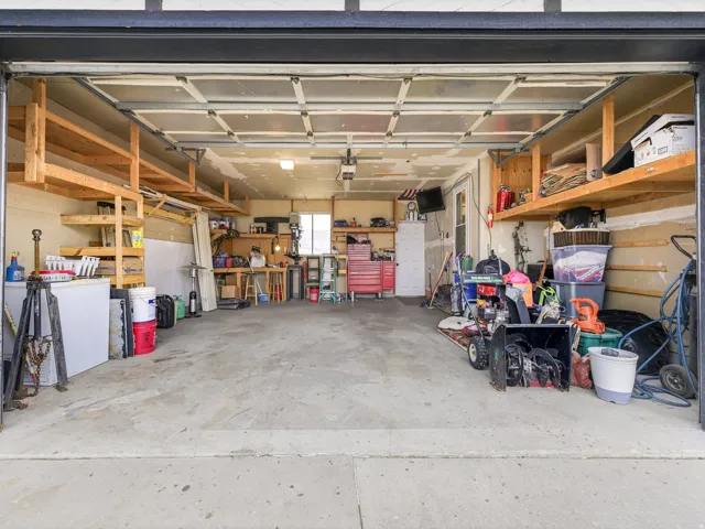 Spacious garage featuring concrete flooring and exposed ceiling beams
