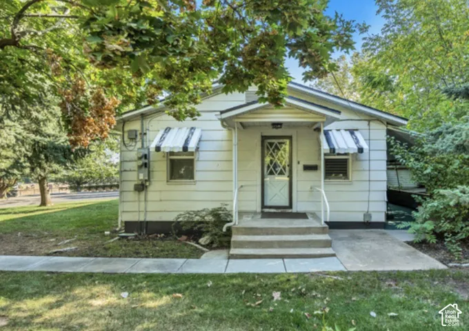 White siding exterior with a covered porch entry