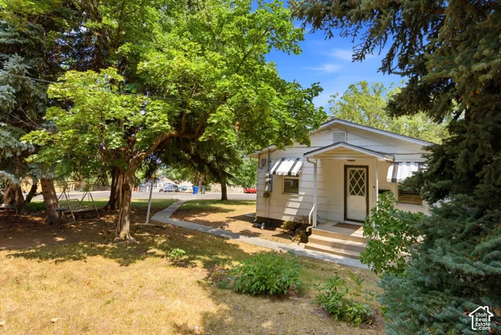 White exterior with a covered porch entry featuring a decorative storm door