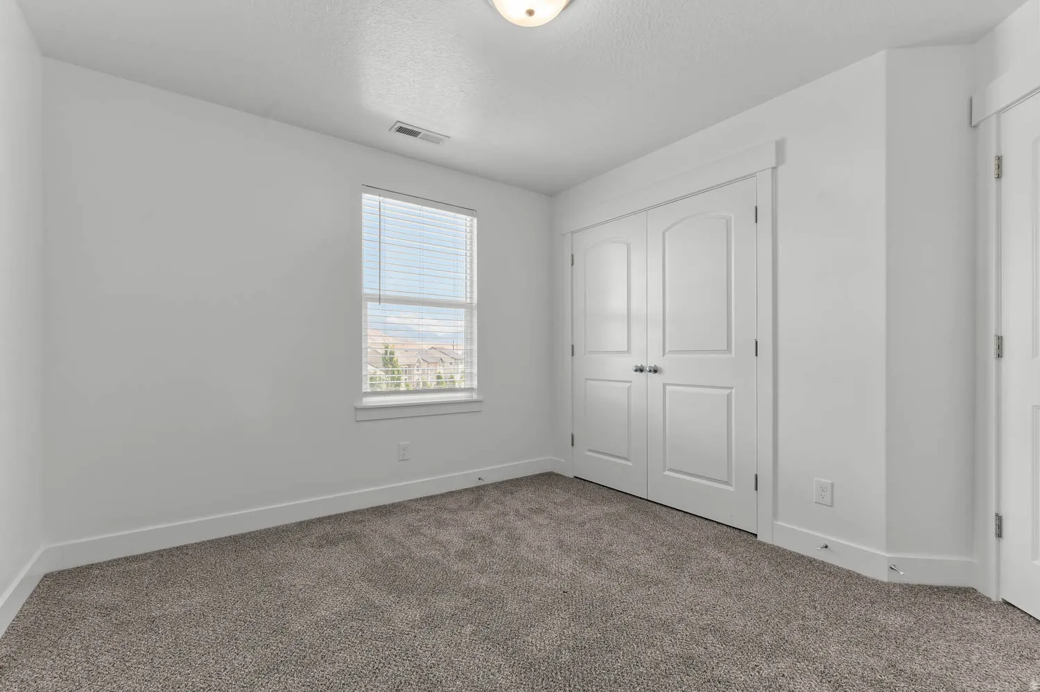 Neutral-toned carpet flooring complementing bright white walls