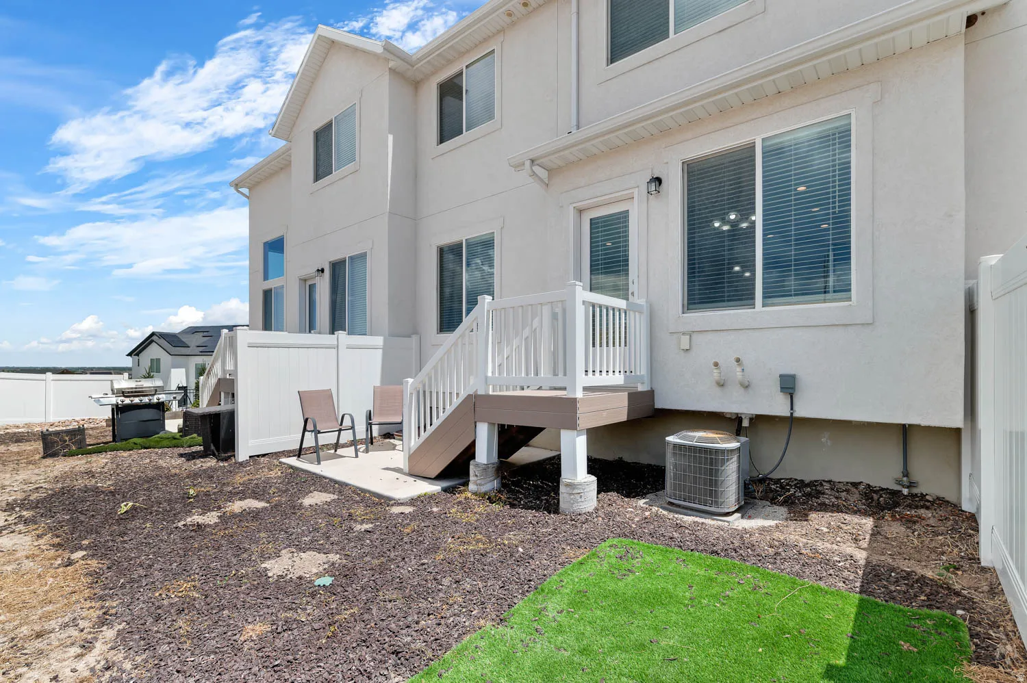 Rear exterior with a composite deck, white railings, and a concrete patio pad