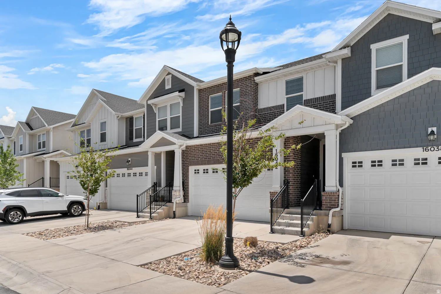 Contemporary multi-story townhome featuring a mix of brick and siding exteriors