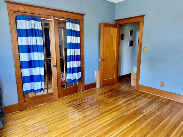 Wood-finish flooring with a polished sheen, framed by classic wood trim