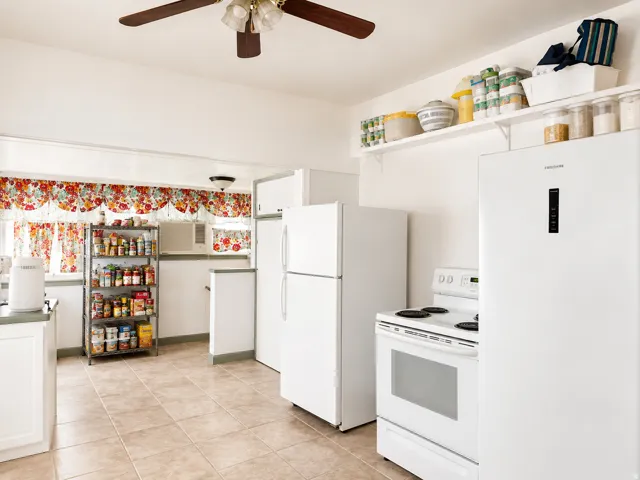 Kitchen featuring tile flooring, white appliances, built-in shelving, a ceiling fan, and white cabinetry