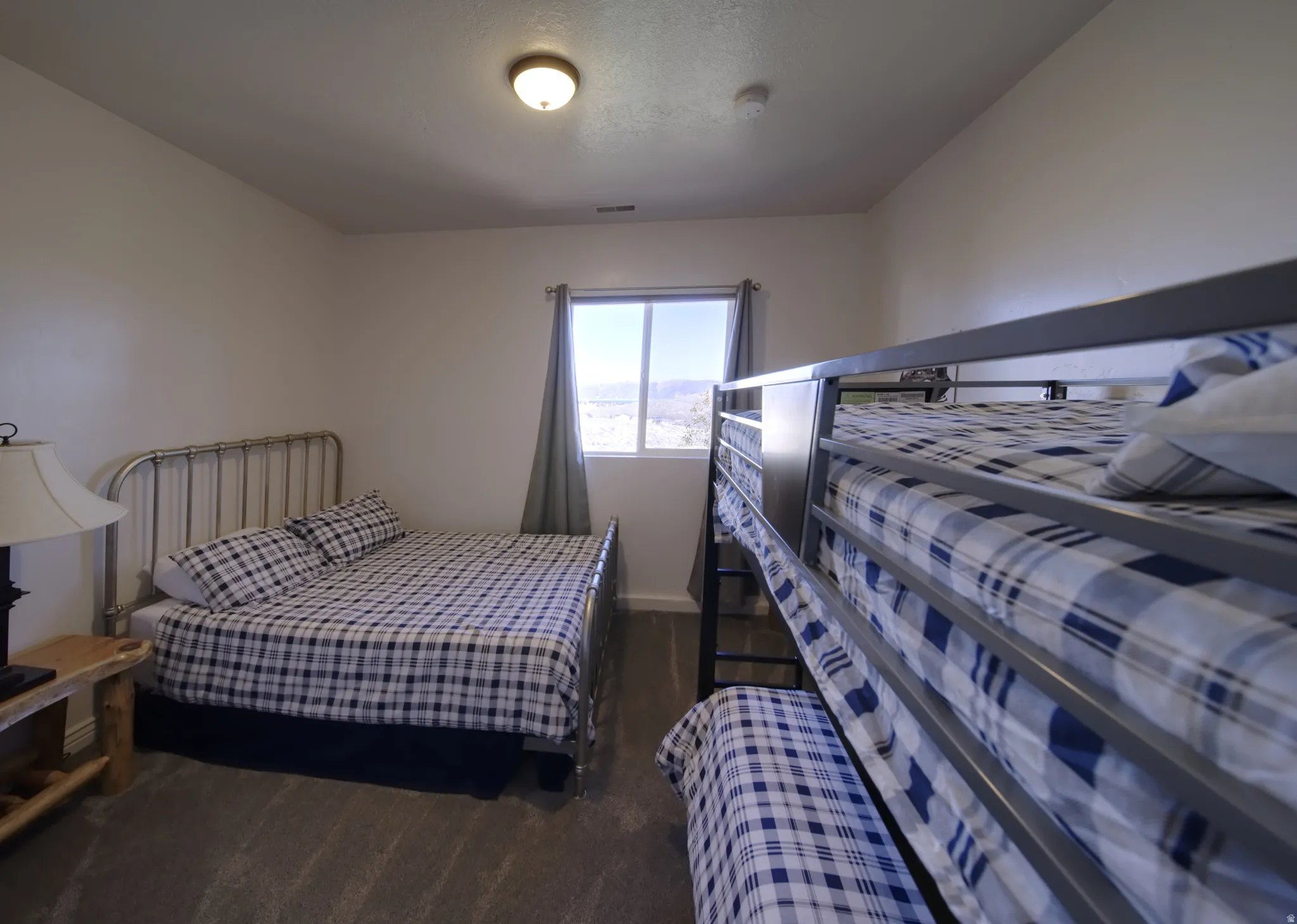 Carpeted bedroom featuring white walls and a ceiling-mounted light fixture