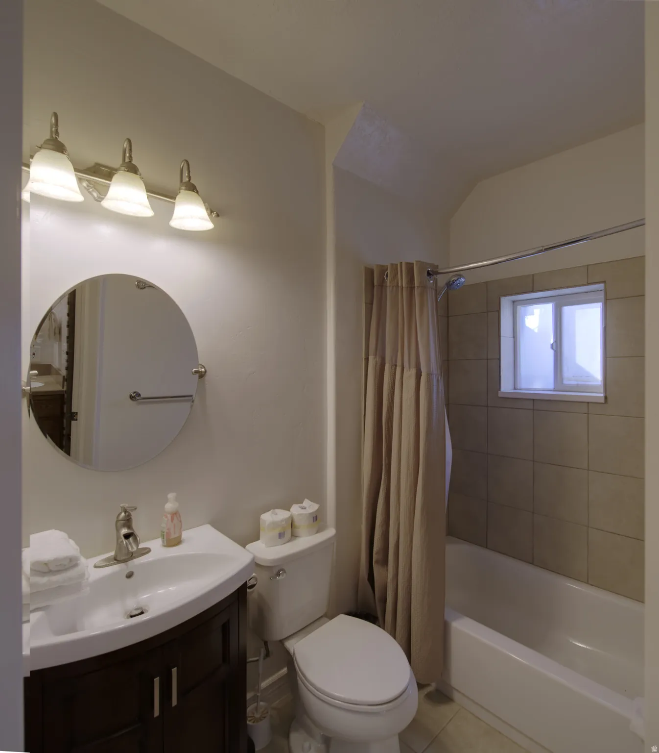 Bathroom featuring a vanity with a dark wood-finish cabinet, white basin, and brushed nickel faucet