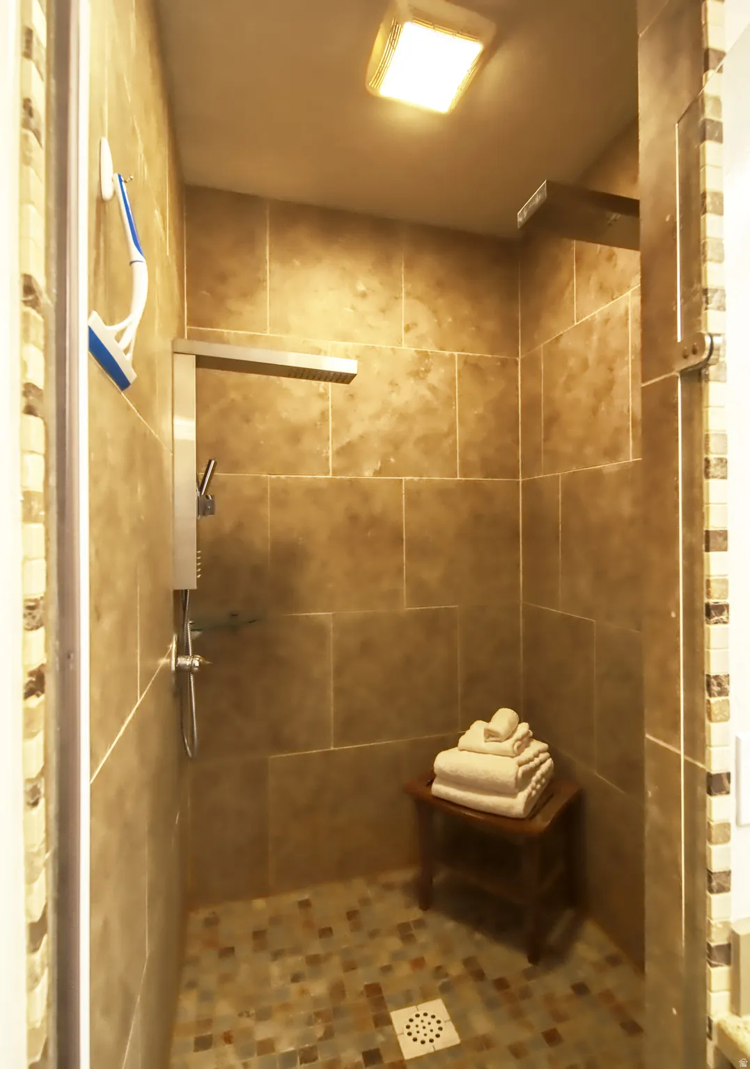 Walk-in shower with large format wall tiling and mosaic tile flooring