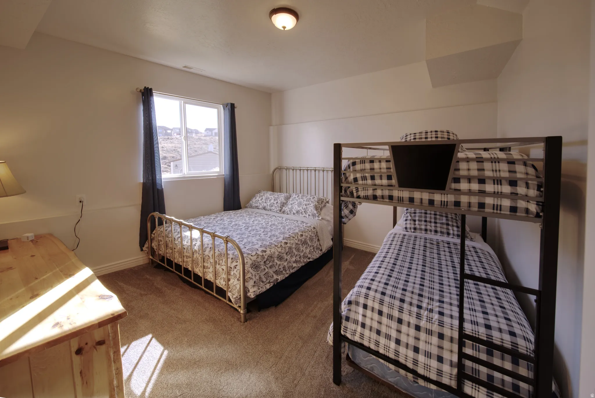 Room featuring light-toned walls, a single window with dark drapes, and a flush mount ceiling light fixture