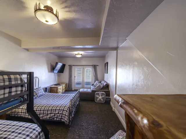 Room featuring textured white walls and dark patterned carpeting