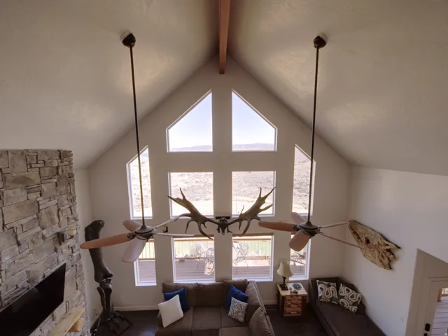 Vaulted ceiling with exposed wood beam and dual ceiling fans